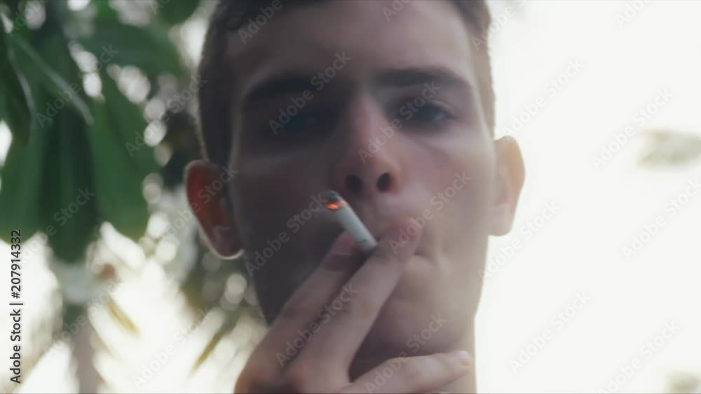 Portrait of young handsome man with cigarette