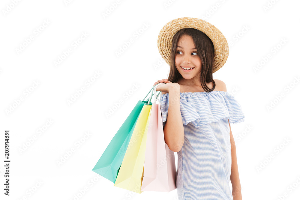 Smiling brunette girl in dress and straw hat holding packages