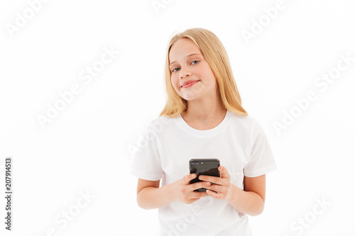 Pleased young blonde girl in casual clothes holding smartphone