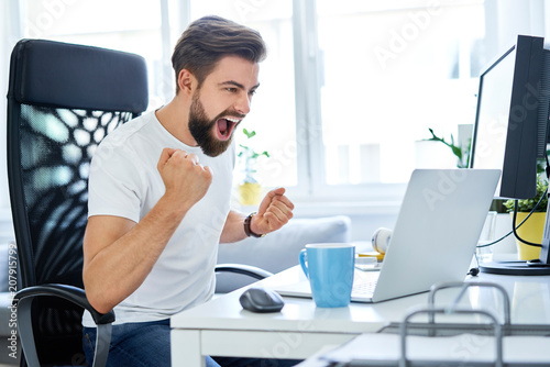 Successful man screaming excited working at home office