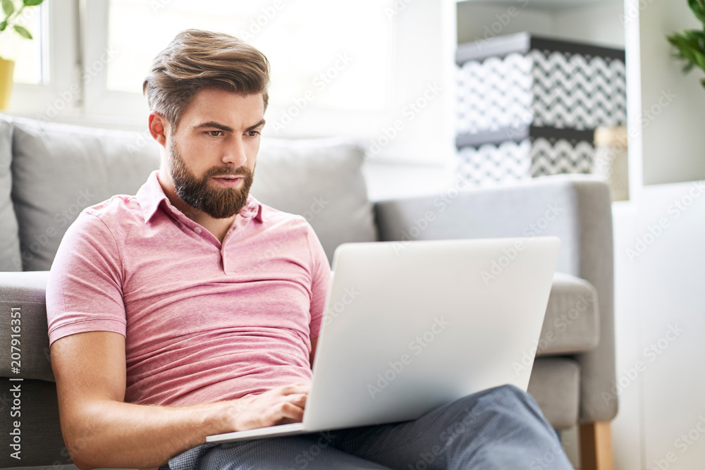 Stressed man with laptop at home typing message Stressed man with laptop at home typing message