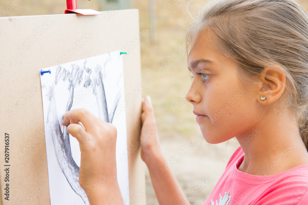 girl draws the lead. Summer creative activity for teenagers. Girls Hand draws a pencil tree trunk on a white sheet. A drawing of nature in black and white
girl draws the lead. Summer creative activity for teenagers. Girls Hand draws a pencil tree trunk on a white sheet. A drawing of nature in black and white