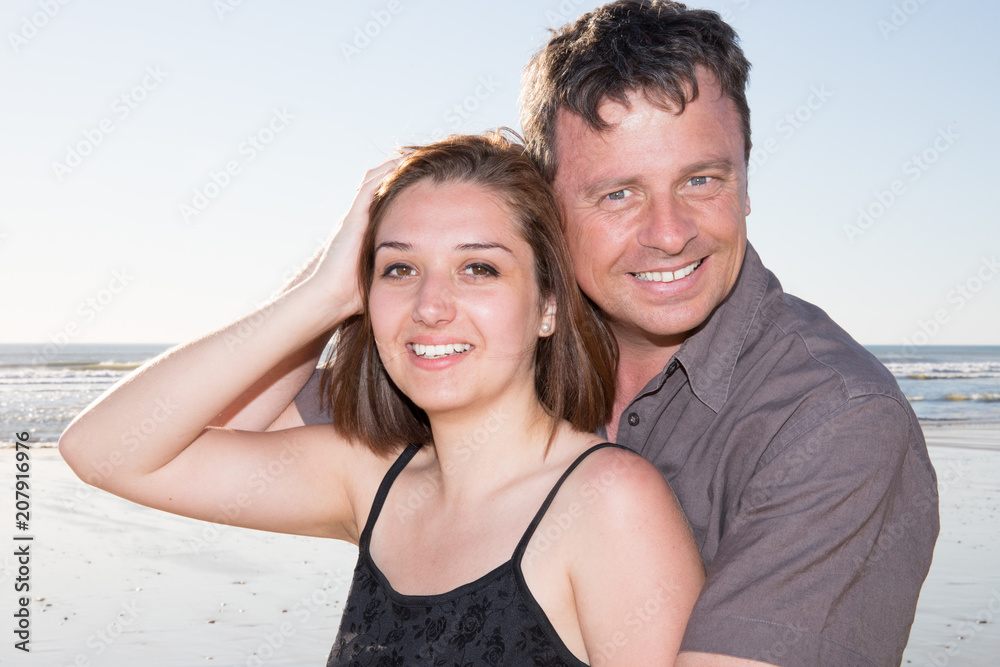 Attractive couple embracing on the beach on a sunny day Attractive couple embracing on the beach on a sunny day