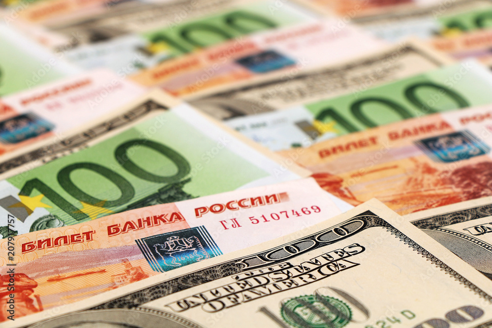 Euro banknotes, US dollars, Russian rubles are lying on the table in a shuffle