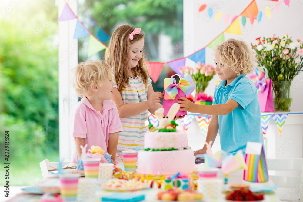 Fototapeta premium Kids birthday party. Children blow cake candles.