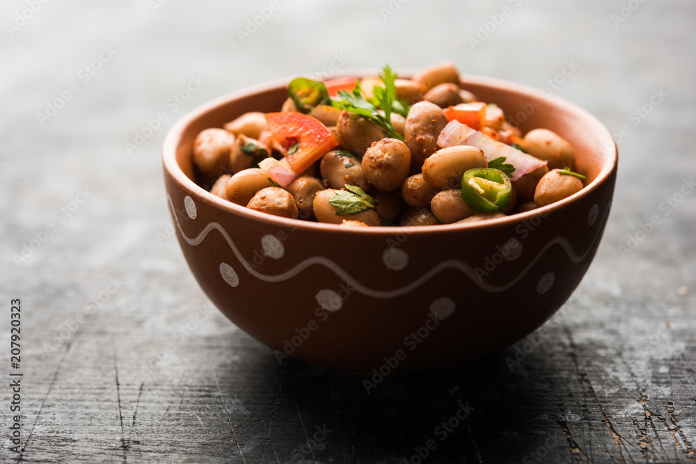 Boiled Peanut Chaat or Chatpata sing dana or shengdana or mungfali. served in a ceramic bowl over moody background - obrazy, fototapety, plakaty 