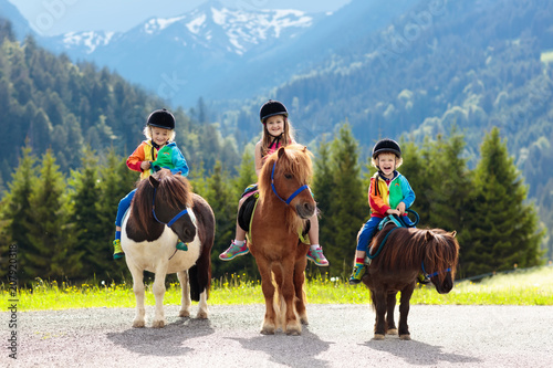 Dzieci jeżdżące na kucyku. Dziecko na koniu w Alpach góry