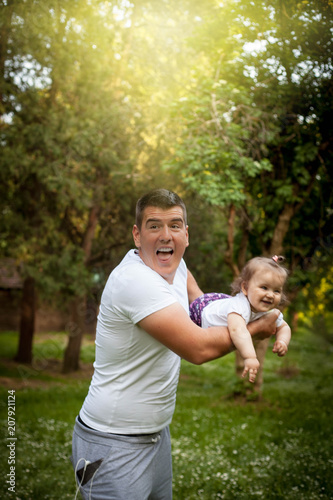 Happy father spinning his small girl in the park. © Natasa