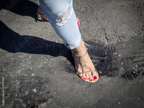 Melting asphalt under the pressure of the feet on a hot sunny day