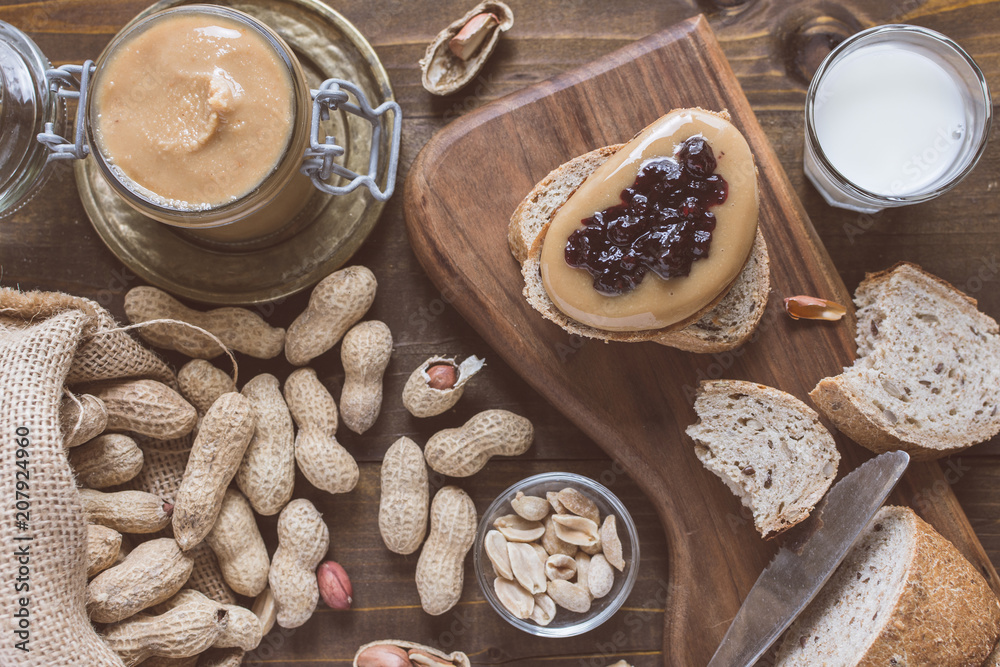 Fototapeta premium Peanut Butter and Jelly Sandwich on Rustic Wooden Cutting Board