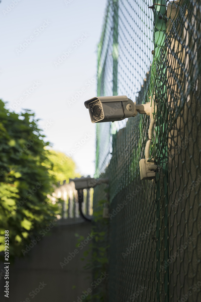 Obraz premium Street surveillance camera on the fence.