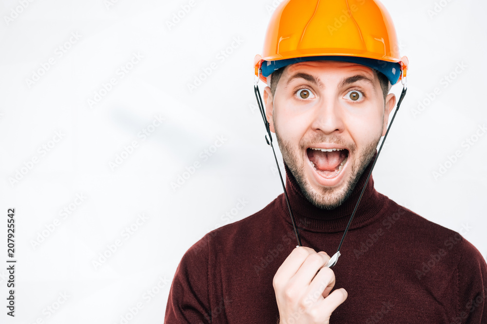 Happy smiling worker on a white background.Worker with orange helmet.Young handsome contractor isolated over white background Happy smiling worker on a white background.Worker with orange helmet.Young handsome contractor isolated over white background