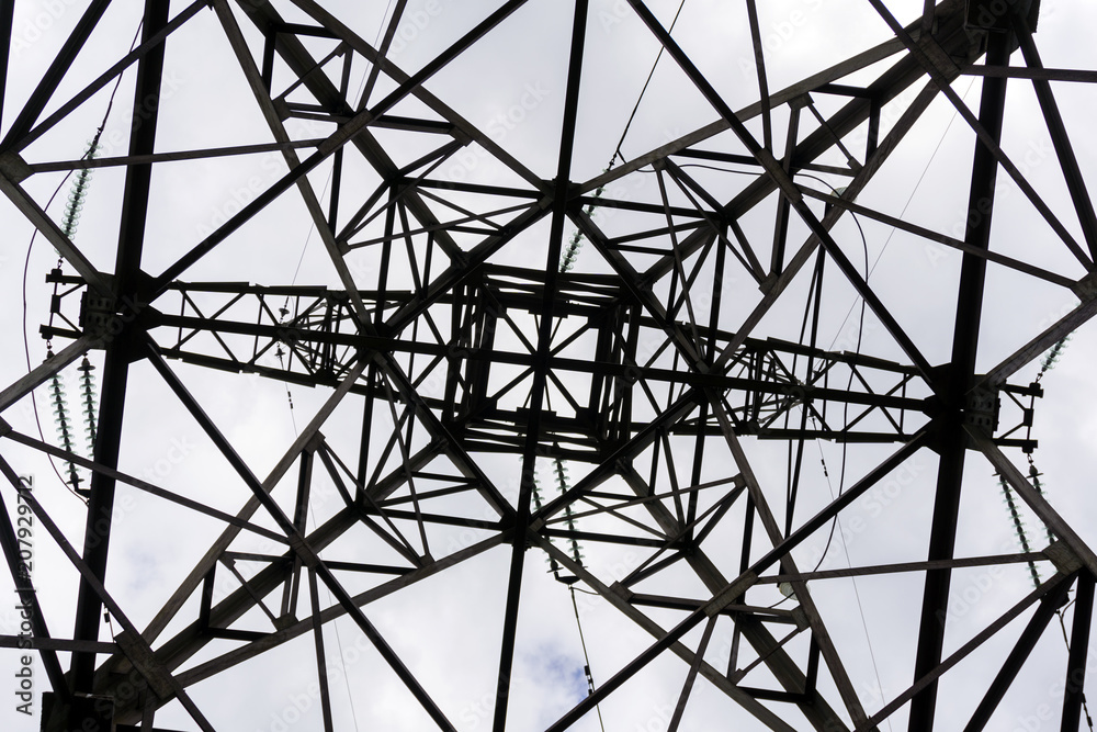 symmetrical pattern formed by a bottom view of a steel grid-shaped power line support