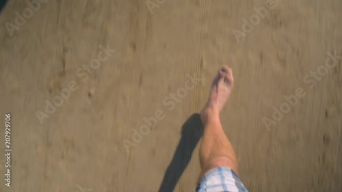 Male feet legs running and finishing stopping on the sandy beach POV shot photo