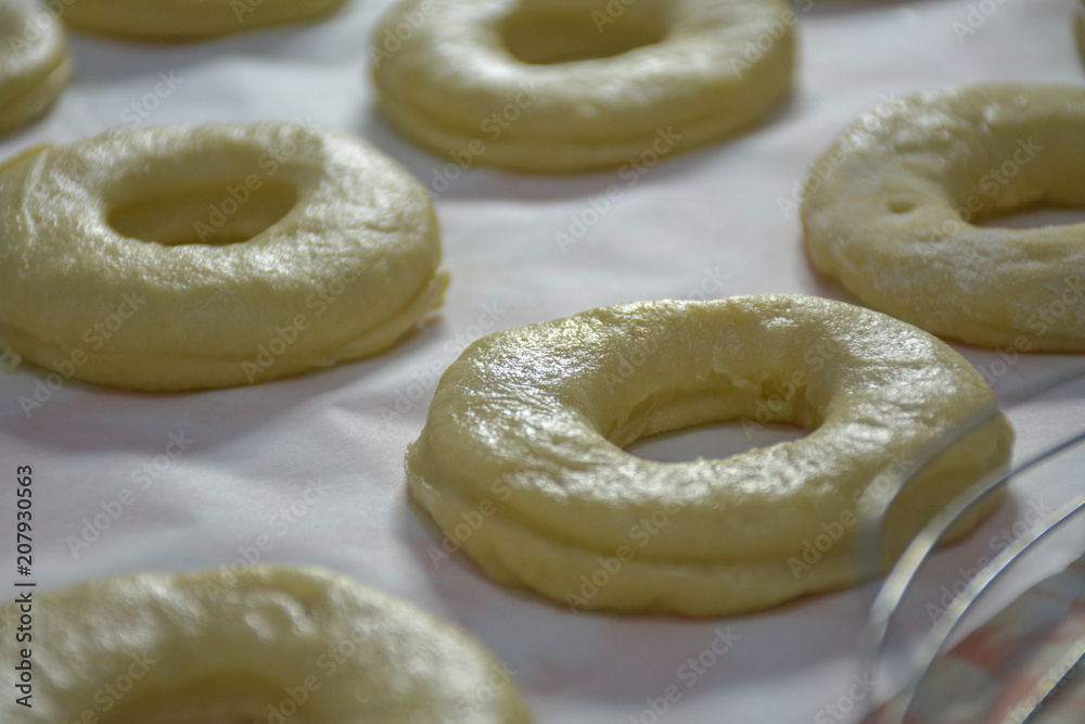 Raw dough donuts prepared on the table ready for frying