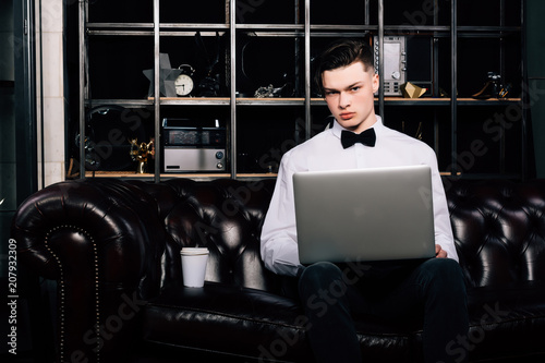 Portrait of handsome young businessman with laptop in office.business man holding a modern laptop computer