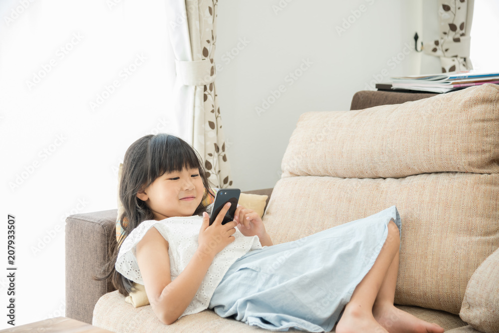 スマートフォンを見ている小学生の女の子 スマートフォンを見ている小学生の女の子