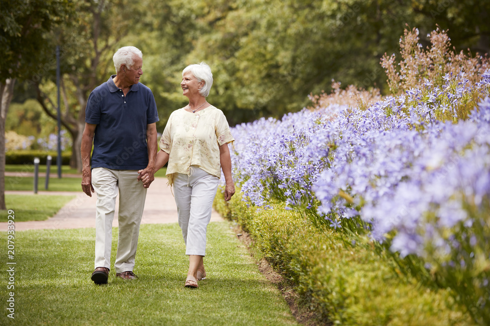 Senior Couple Holding Hands On Romantic Walk In Park Together Stock ...
