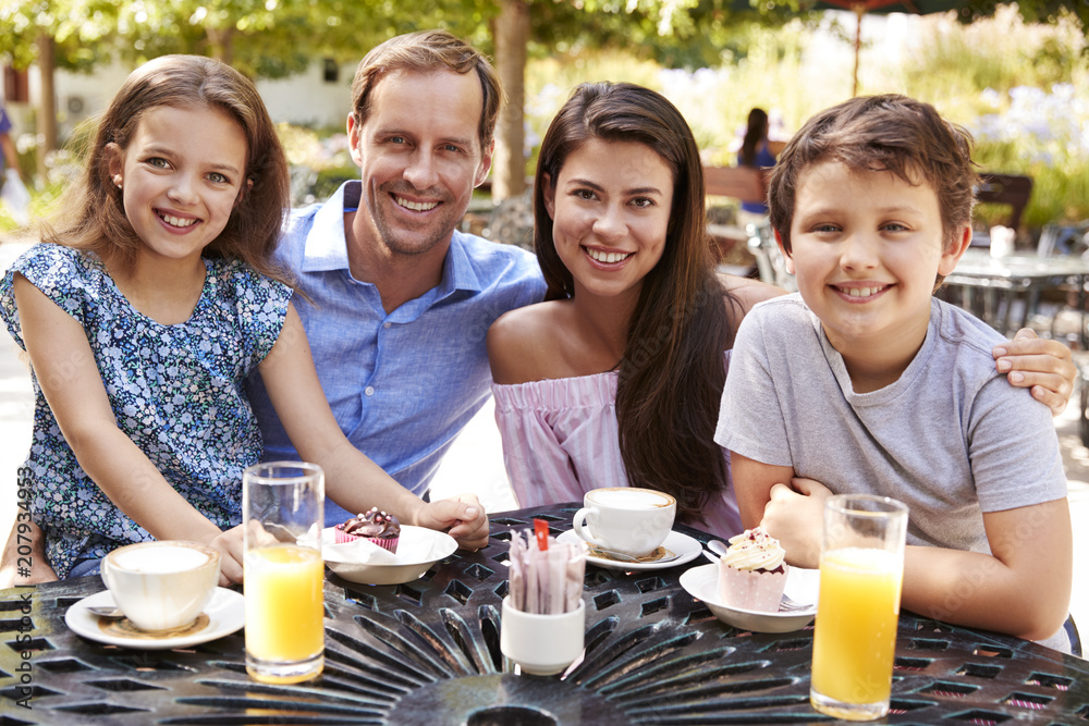 Portrait Of Family Enjoying Snack At Outdoor CafŽ Together