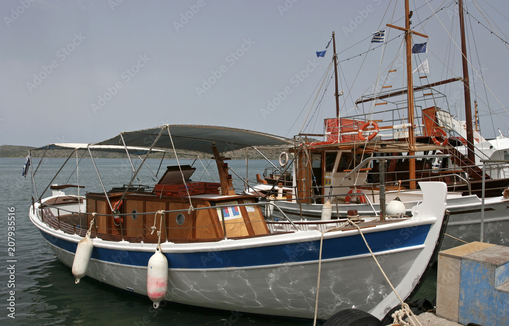 The white boats in the marina in the small Mediterranean town on the sunny day.