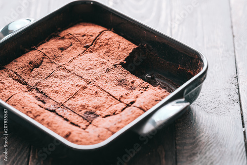 Decadent moist dark chocolate stout beer brownies cut in squares. Black ceramic bakeware. Dark food photography concept photo