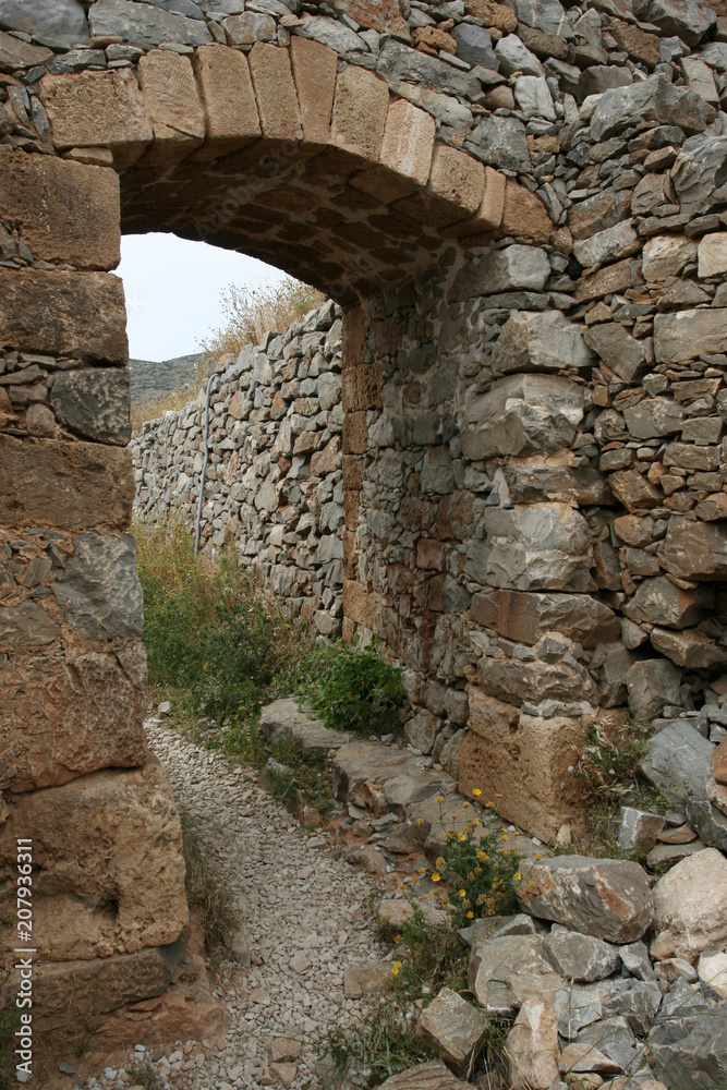 The arc in the old stone wall of the Venetian fortress on the small Mediterranean island Spinalonga near Crete. 