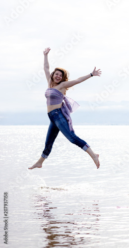 Ukrainian woman jumping joyfully on the shore of the beach