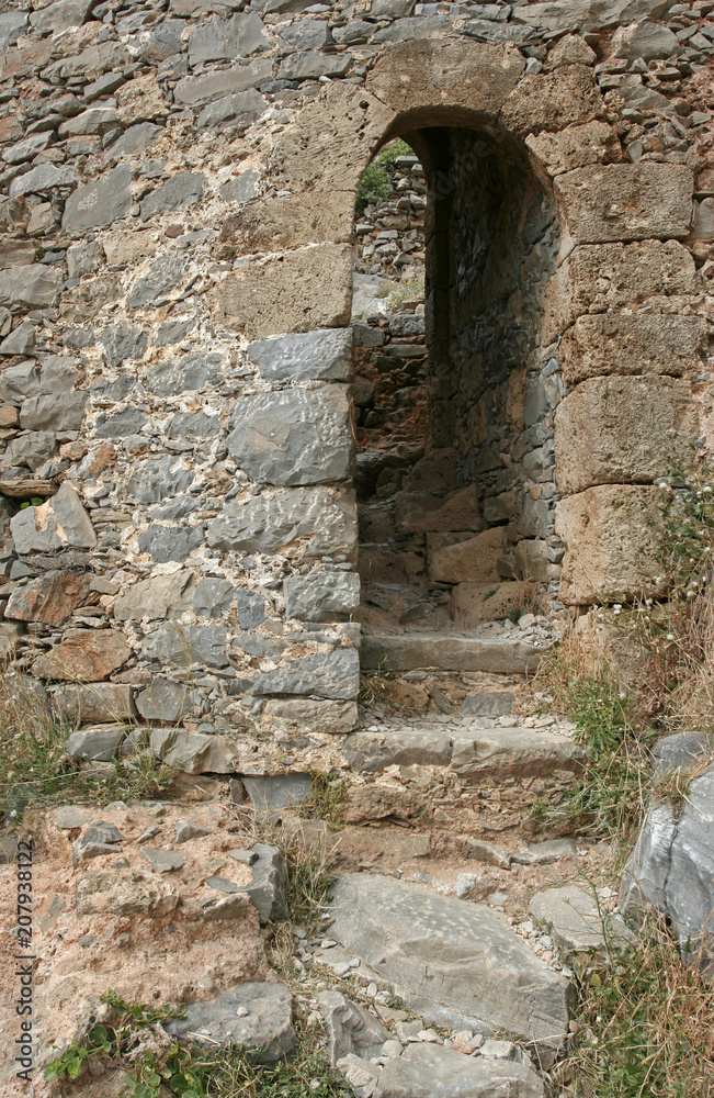 The arc with steps in the old stone wall of the Venetian fortress on the small Mediterranean island Spinalonga near Crete. 