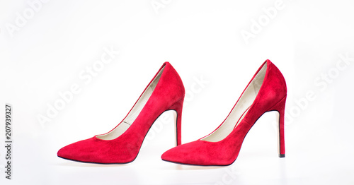 Shoes made out of red suede on white background, isolated. Pair of fashionable high heeled pump shoes. Elegant stiletto shoes concept. Footwear for women with thin high heels.