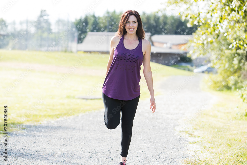 Healthy, active woman stretching her legs during workout