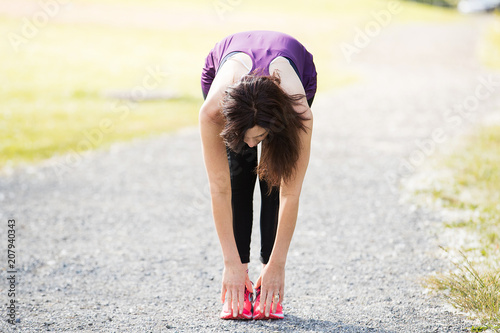 Healthy woman stretching and touching her toes