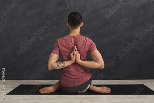 Young man practicing yoga, Reverse Prayer Pose