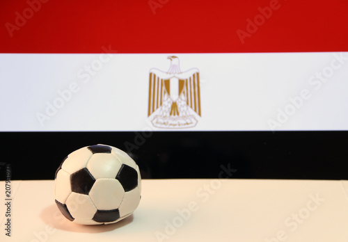 Small football on the white floor and Egyptian nation flag background. The concept of sport.