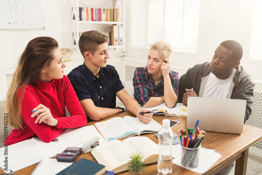 Group of diverse students studying at wooden table Group of diverse students studying at wooden table