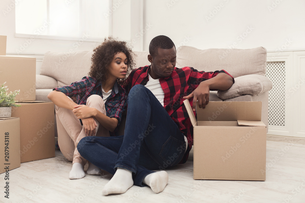Young balck couple unpacking moving boxes Young balck couple unpacking moving boxes
