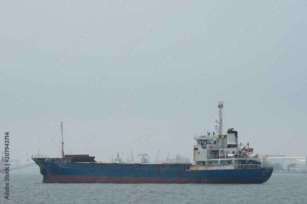KAOHSIUNG, TAIWAN - CIRCA June, 2018:A large cargo ship moves towards the exit of Kaohsiung harbor KAOHSIUNG, TAIWAN - CIRCA June, 2018:A large cargo ship moves towards the exit of Kaohsiung harbor