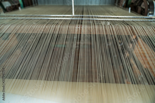 Silk threads on weaving machine. Vietnamese handmade silk producing