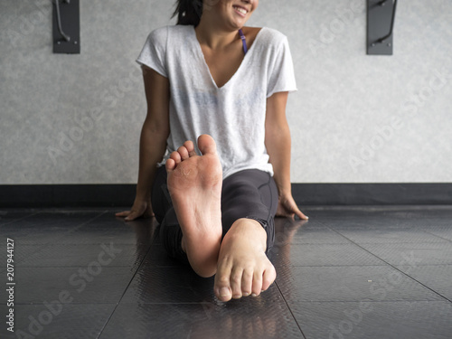 Smiling dancer warming up her feet with alternating pointing and flexing photo