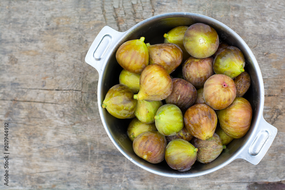 Green sweet figs bowl on old wooden desk. Harvest. Green sweet figs bowl on old wooden desk. Harvest.