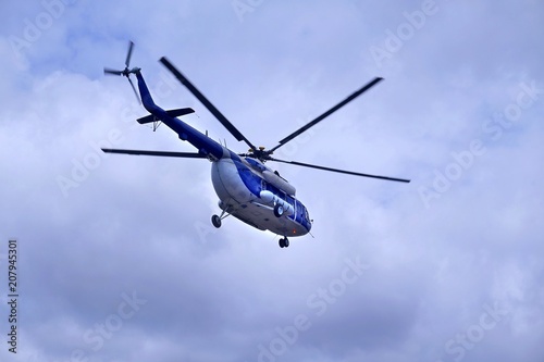 White blue helicopter on the sky background.
