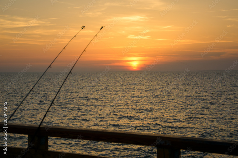 fishing rods on a background of sunset on the Baltic Sea, Kaliningrad.