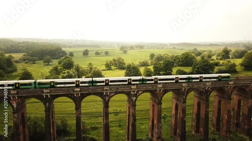 Aerial of a train riving over The Ouse Valley Viaduct across the river Ouse in Sussex England  photo