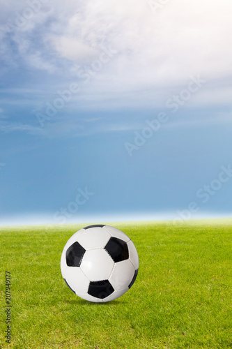 Fliegender Fu  ball   ber dem Rasen vor blauem Himmel