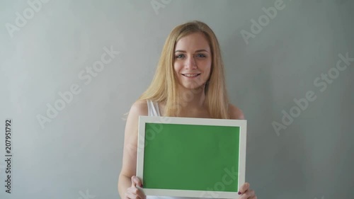 Attractive Woman shows greenkey copyspace with tracking points. photo