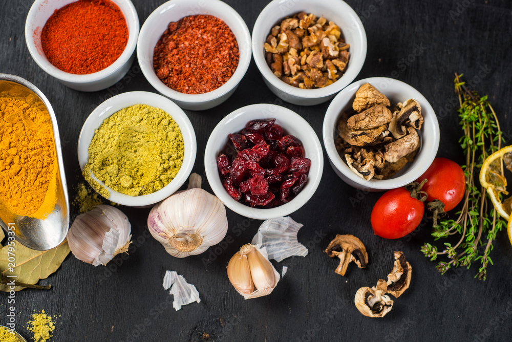 Different spices with raw and dry vegetables on black background. Top view. copy space Different spices with raw and dry vegetables on black background. Top view. copy space