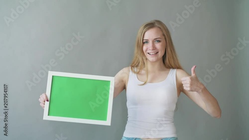 Attractive Woman shows greenkey copyspace with tracking points. photo