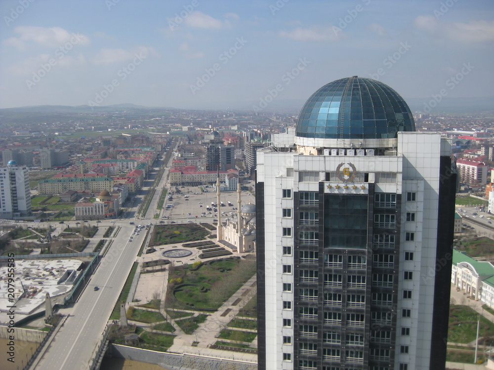 Grozny is the capital of the Chechen Republic in the North Caucasus in Russia. The center of the city is Putin Avenue. In the foreground, high-rise office building .
