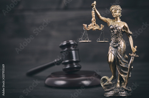 Scales of Justice, Judge Gavel, Justitia, Lady Justice on a black wooden background.