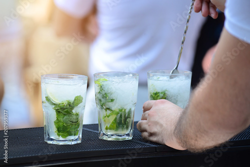 bartender preparing mojito cocktail in outdoor bar