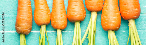 carrots on a blue wooden background, fresh vegetables, carotene, banner